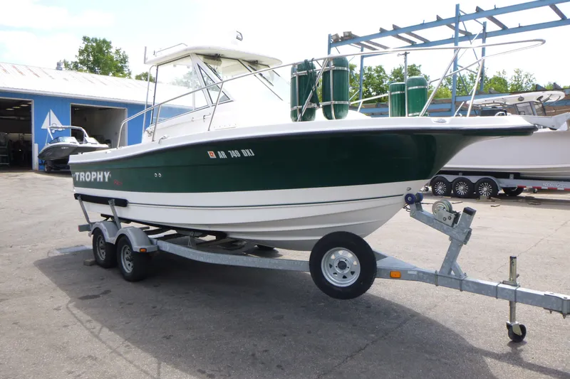 Slide: The Image of 2010 Trophy 2152 Walkaround boat on trailer, parked outside a blue building. - 3