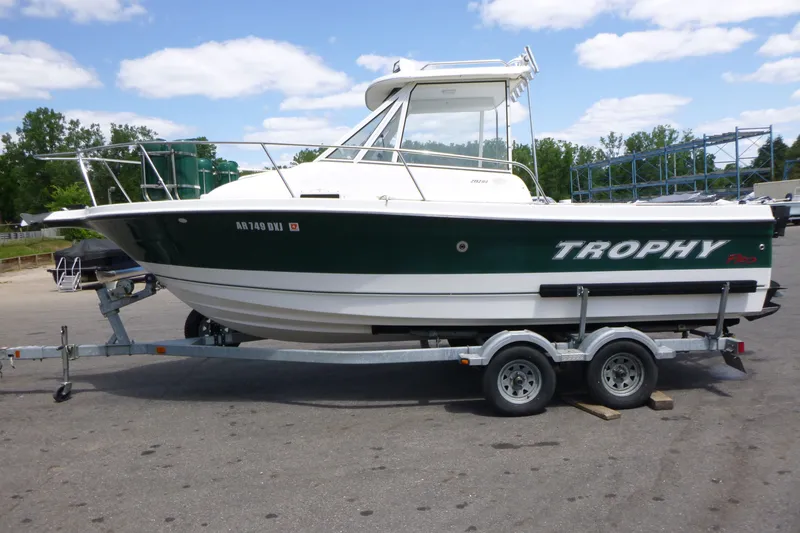 Slide: The Image of 2010 Trophy 2152 Walkaround boat on trailer, parked outdoors under a partly cloudy sky. - 4