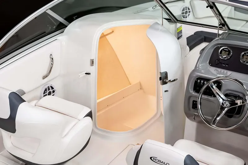 Slide: The Image of Manufacturer Provided Image: 2025 Robalo R207 Dual Console interior with open storage compartment and steering wheel. - 13