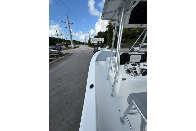 Slide: The Image of 2006 Sea Hunt BX22 boat with Garmin navigation, parked on a street under a blue sky. - 13