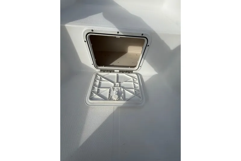 Slide: The Image of Open storage compartment on a 2006 Sea Hunt BX22 boat deck. - 23