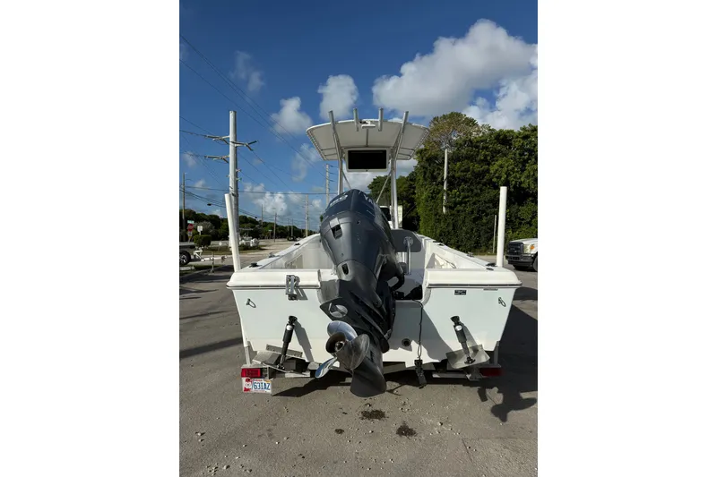 Slide: The Image of 2006 Sea Hunt BX22 boat with outboard motor on trailer, parked outdoors. - 9