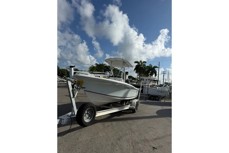 Slide: The Image of 2006 Sea Hunt BX22 boat on trailer under a partly cloudy sky. - 6