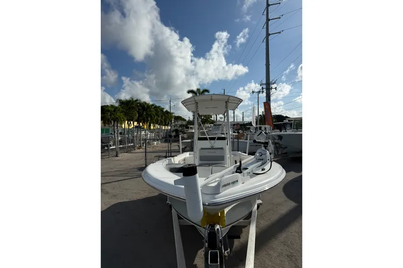 Slide: The Image of 2006 Sea Hunt BX22 boat on trailer under a partly cloudy sky. - 2