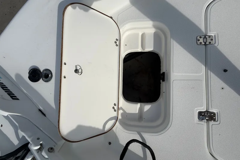Slide: The Image of 2006 Sea Hunt BX22 boat hatch with open storage compartment and visible hardware. - 20