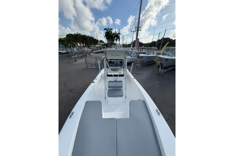 Slide: The Image of 2006 Sea Hunt BX22 boat with gray seating, parked outdoors under a partly cloudy sky. - 17