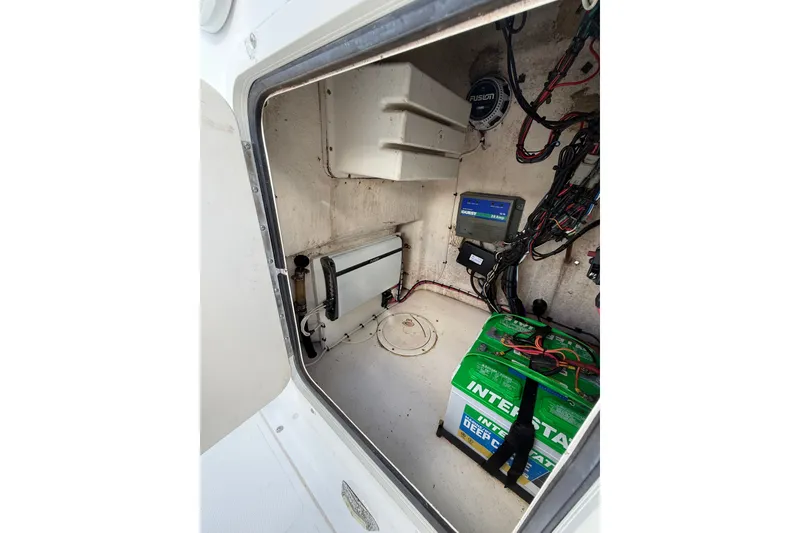 Slide: The Image of 2006 Sea Hunt BX22 boat compartment with battery and wiring setup. - 21