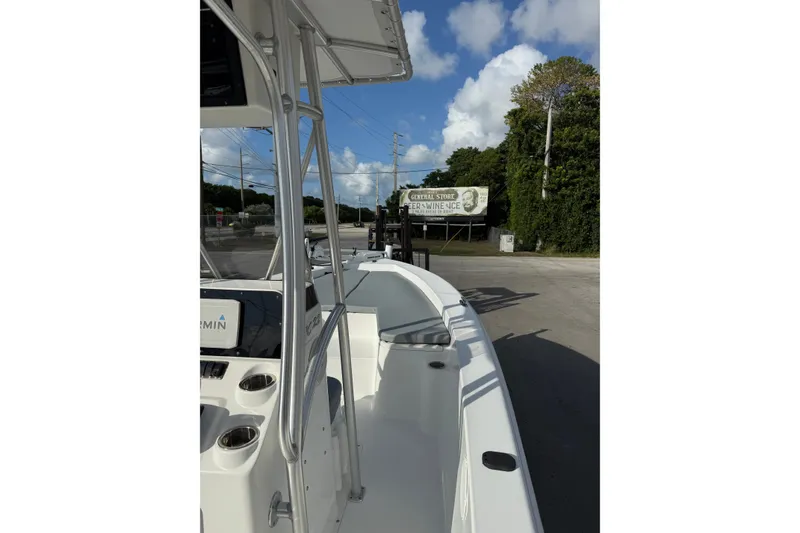 Slide: The Image of 2006 Sea Hunt BX22 boat docked near a general store under a clear blue sky. - 15