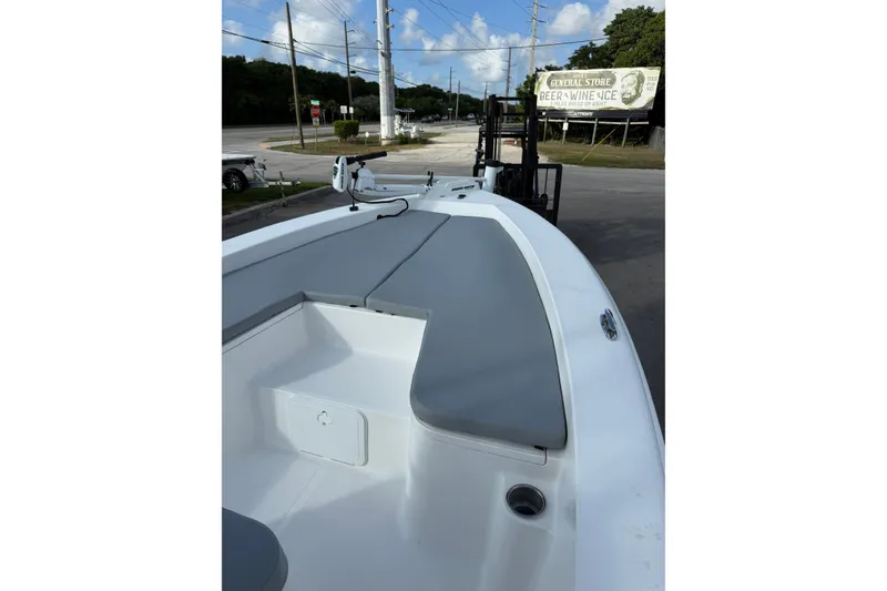 Slide: The Image of 2006 Sea Hunt BX22 boat with gray seating, parked near a road and store sign. - 16