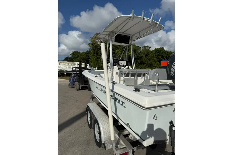 Slide: The Image of 2006 Sea Hunt BX22 boat on trailer, parked outdoors under a cloudy sky. - 10