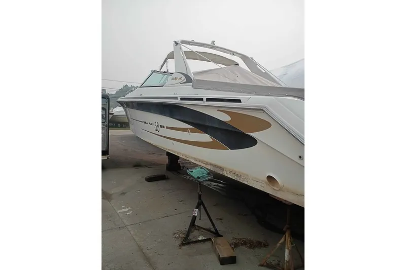 Slide: The Image of 1995 Searay SUNSPORT 38 boat on stands, side view, in a marina setting. - 2
