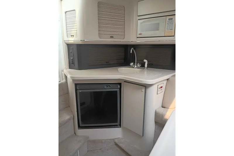 Slide: The Image of Compact kitchen area in a 1995 Searay SUNSPORT 38 boat, featuring a sink and microwave. - 6
