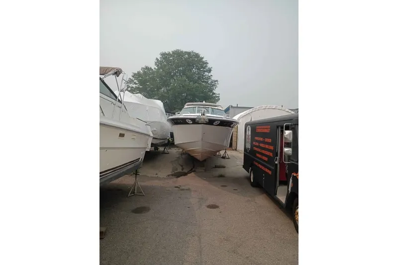 Slide: The Image of 1995 Searay SUNSPORT 38 boat on stands, surrounded by other boats and a service truck. - 4
