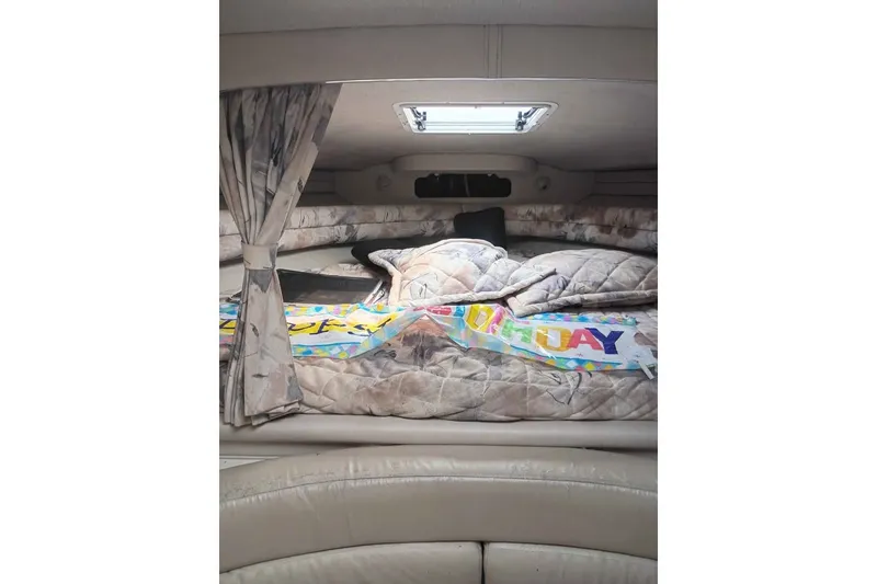 Slide: The Image of Interior cabin of a 1995 Searay SUNSPORT 38 with cozy bedding and curtains. - 7