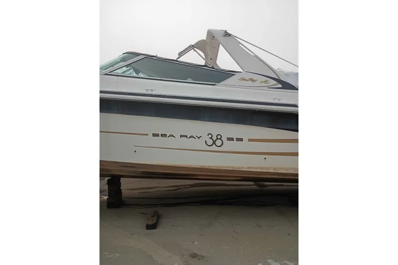 Slide: The Image of 1995 Searay SUNSPORT 38 boat on dry dock, side view with branding visible. - 1