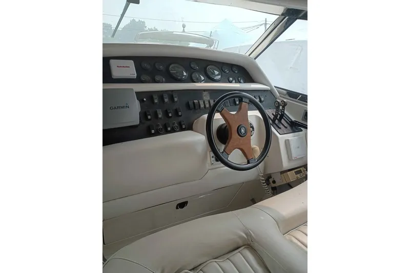 Slide: The Image of 1995 Searay SUNSPORT 38 boat cockpit with steering wheel and navigation instruments. - 10