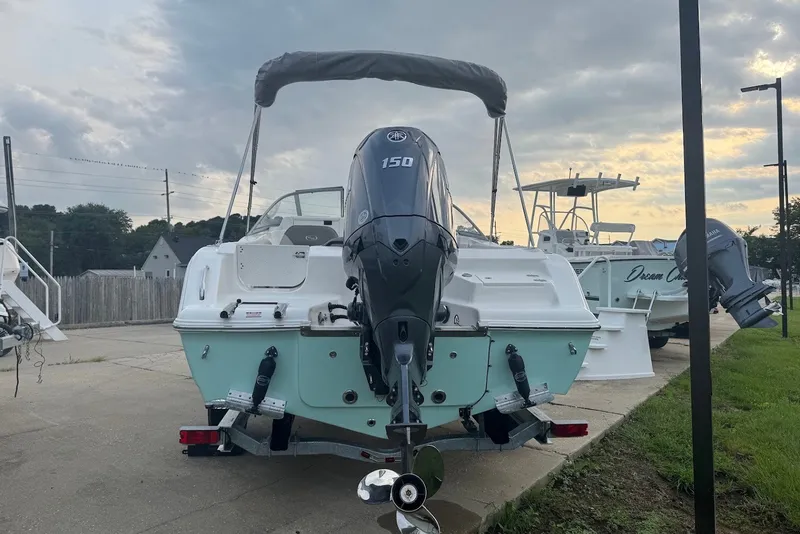 Slide: The Image of 2027 Key West 203 DFS boat with outboard motor on a trailer, parked outdoors. - 2
