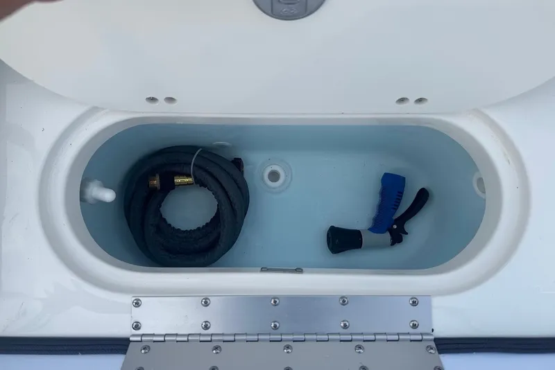 Slide: The Image of Storage compartment of 2027 Key West 203 DFS boat with hose and brush. - 11