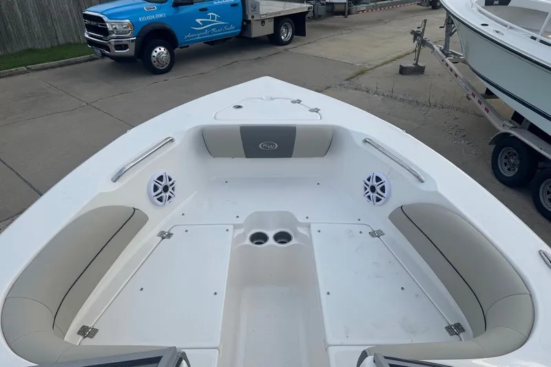 Slide: The Image of 2027 Key West 203 DFS boat interior with seating and speakers, parked near a blue truck. - 8