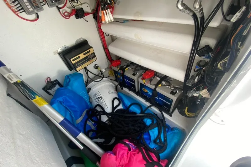 Slide: The Image of 2022 Sportsman Open 232 Center Console storage with batteries, wiring, and safety equipment. - 28