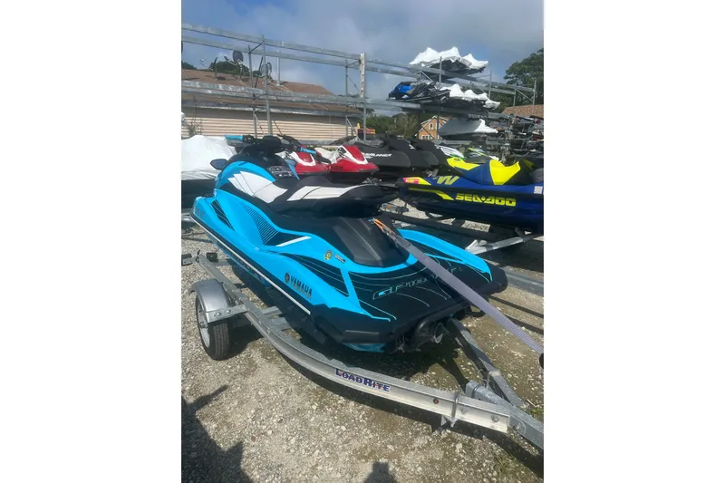 Slide: The Image of 2022 Yamaha WaveRunner GP HO in blue on a trailer, parked outdoors. - 5