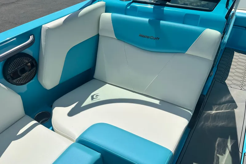Slide: The Image of 2024 MasterCraft NXT22 boat interior with blue and white seating and speaker detail. - 12