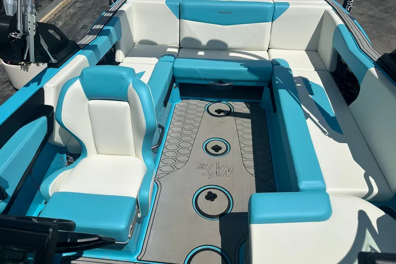 Slide: The Image of 2024 MasterCraft NXT22 boat interior with blue and white seating and stylish flooring. - 11