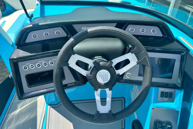 Slide: The Image of 2024 MasterCraft NXT22 boat dashboard with steering wheel and control panel. - 14