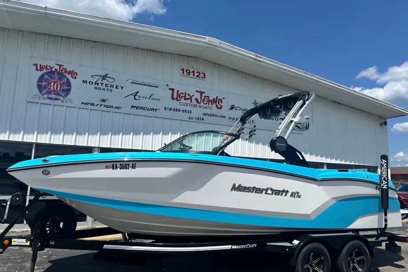 Slide: The Image of 2024 MasterCraft NXT22 boat in blue and white, displayed at Ugly John's Custom Boats. - 3