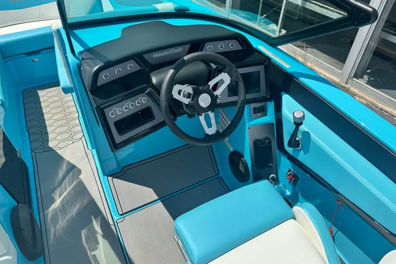 Slide: The Image of 2024 MasterCraft NXT22 boat interior with blue accents and modern dashboard design. - 13