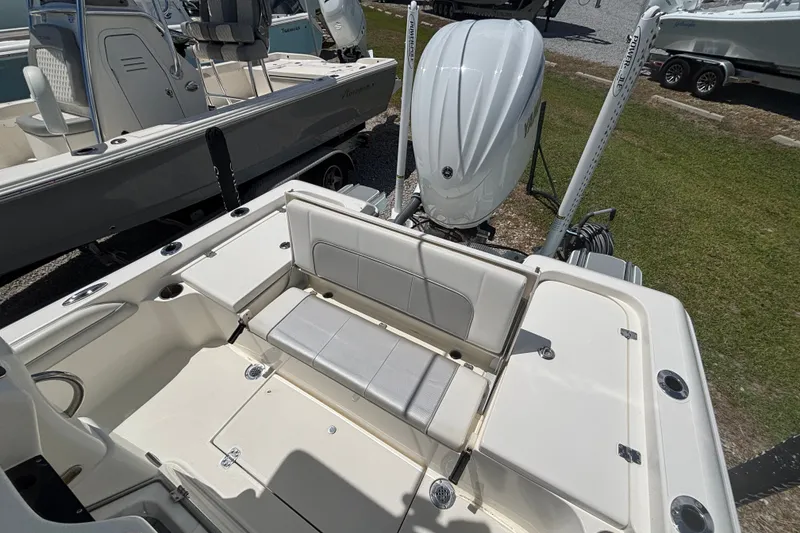 Slide: The Image of 2022 ShearWater 250 XTE boat with seating and outboard motor, parked on grass. - 10