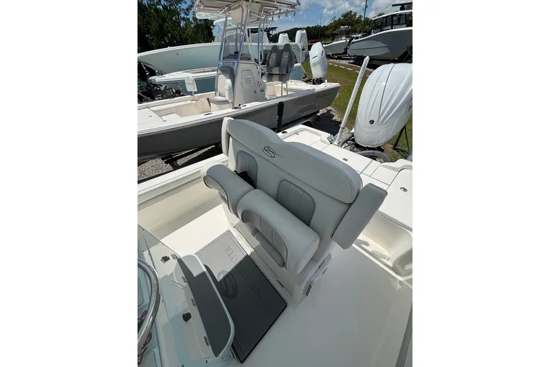 Slide: The Image of 2022 ShearWater 250 XTE boat interior with cushioned seating and helm station. - 8
