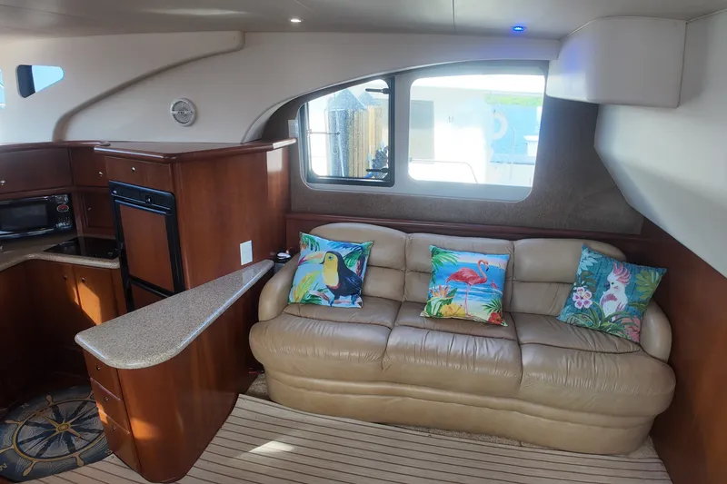 Slide: The Image of Interior of 2006 Silverton 35 Motor Yacht with tropical-themed cushions on a leather sofa. - 13