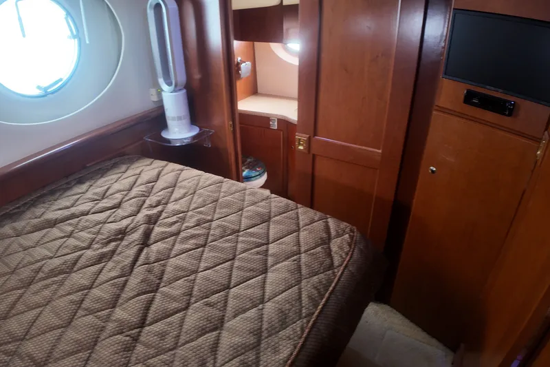 Slide: The Image of Interior cabin of 2006 Silverton 35 Motor Yacht with bed, porthole, and TV. - 14