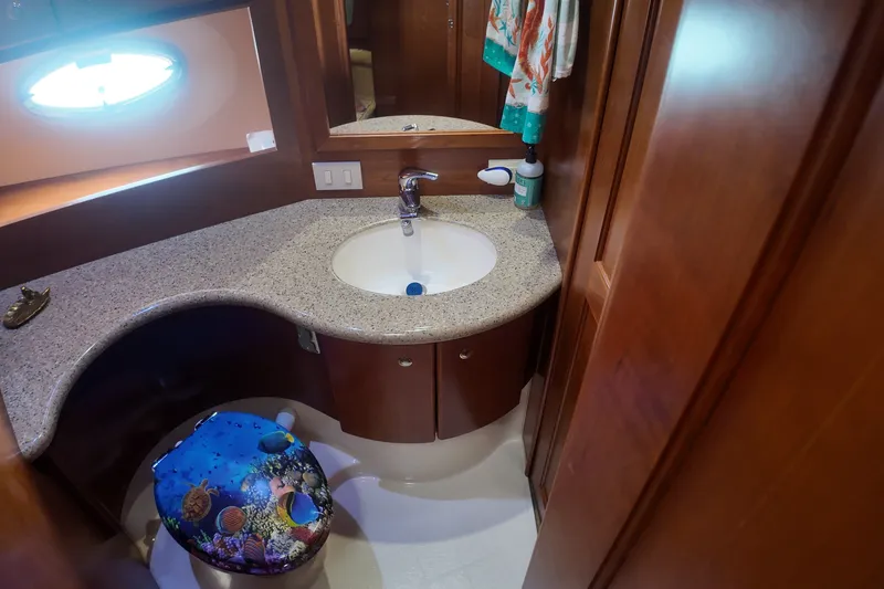 Slide: The Image of Bathroom interior of 2006 Silverton 35 Motor Yacht with granite countertop and ocean-themed decor. - 19