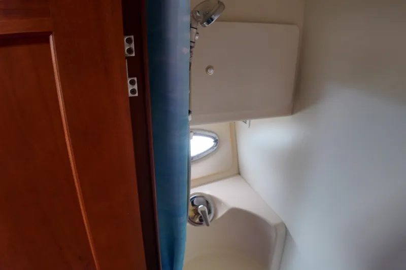 Slide: The Image of Interior view of 2006 Silverton 35 Motor Yacht bathroom with wooden door and porthole. - 21