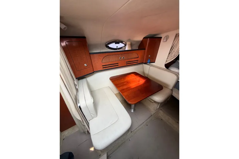 Slide: The Image of Interior of 2005 Sea Ray Sundancer 280 with cozy seating and wooden table. - 25
