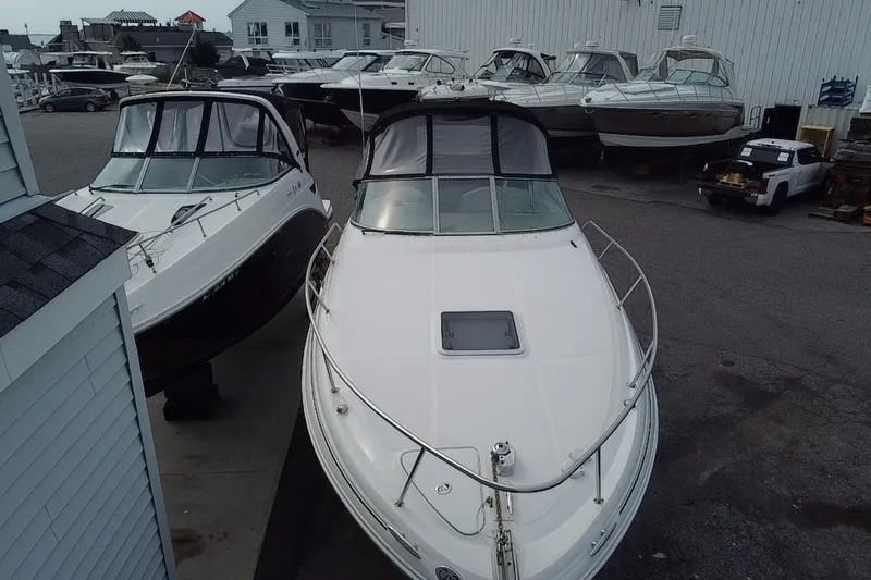 Slide: The Image of 2005 Sea Ray Sundancer 280 boat docked at a marina with other vessels. - 6