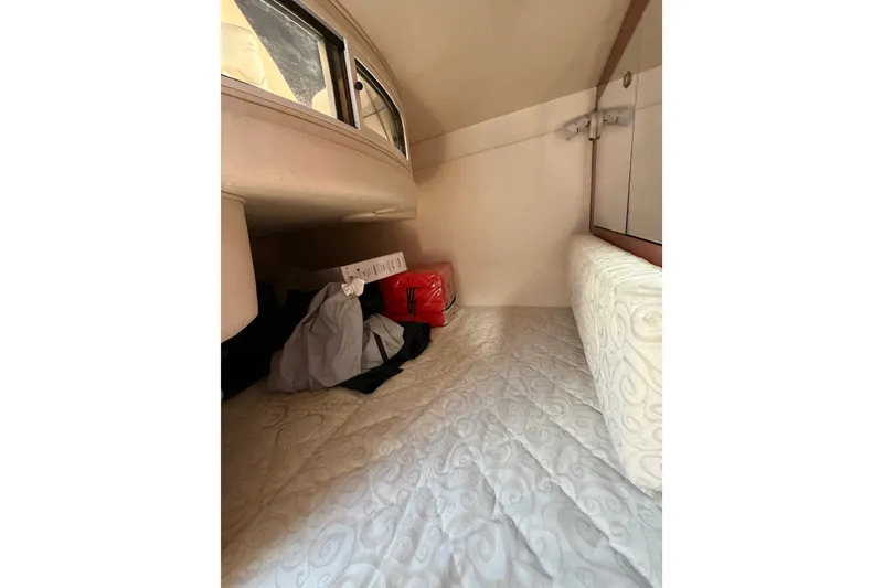Slide: The Image of 2005 Sea Ray Sundancer 280 cabin interior with bed and storage space. - 29