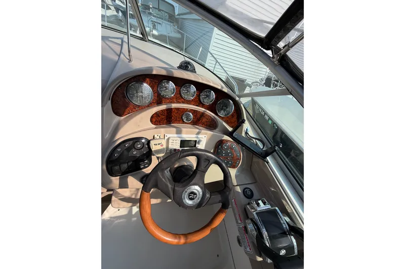 Slide: The Image of 2005 Sea Ray Sundancer 280 helm with wood accents and modern controls. - 23