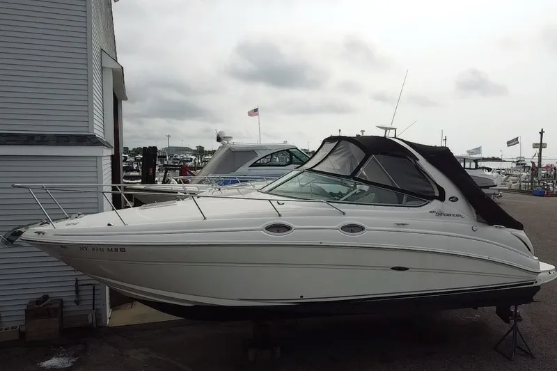 Slide: The Image of 2005 Sea Ray Sundancer 280 docked at a marina, featuring sleek design and covered cockpit. - 3