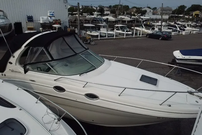 Slide: The Image of 2005 Sea Ray Sundancer 280 docked at a marina, surrounded by other boats. - 11