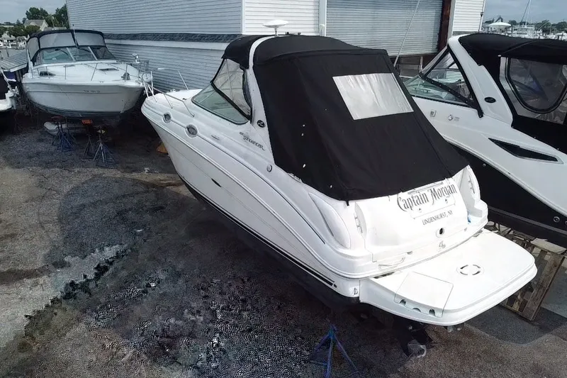 Slide: The Image of 2005 Sea Ray Sundancer 280 boat with black cover, docked outdoors. - 16