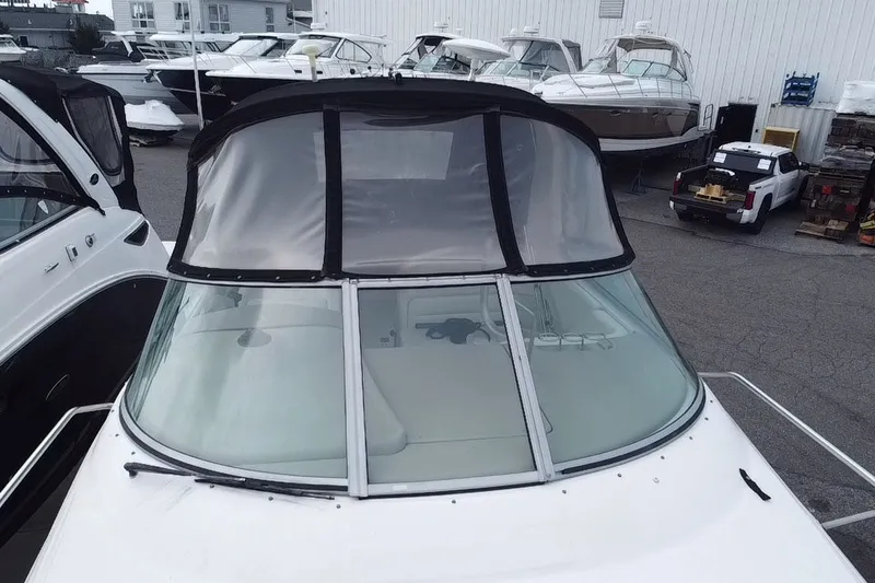 Slide: The Image of 2005 Sea Ray Sundancer 280 boat with covered cockpit, docked among other vessels. - 7
