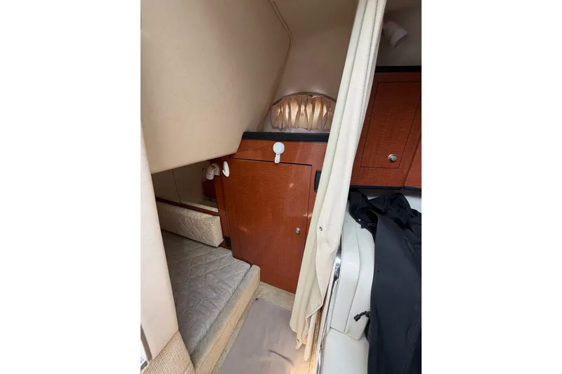 Slide: The Image of 2005 Sea Ray Sundancer 280 cabin interior with wood cabinetry and cozy sleeping area. - 28