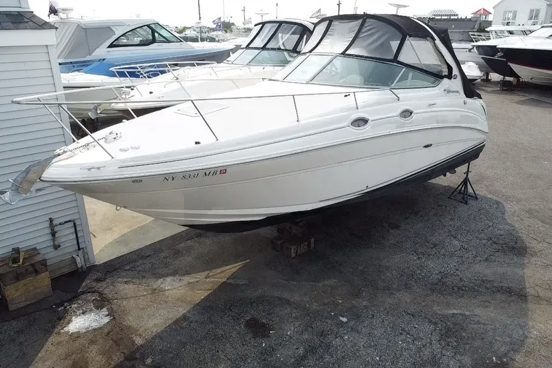 Slide: The Image of 2005 Sea Ray Sundancer 280 boat on dry dock, white exterior, marina background. - 19