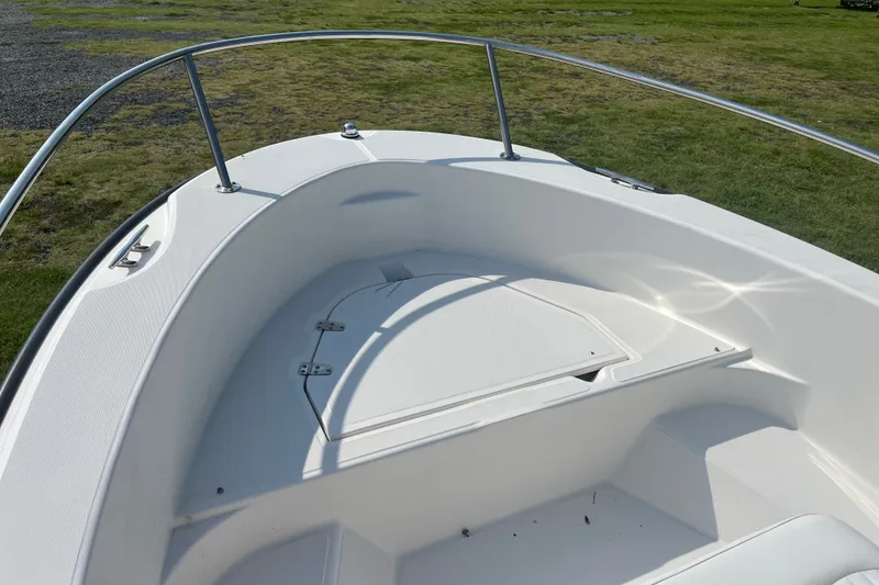 Slide: The Image of 2007 Boston Whaler 180 Dauntless boat bow with storage compartment, on grassy area. - 8