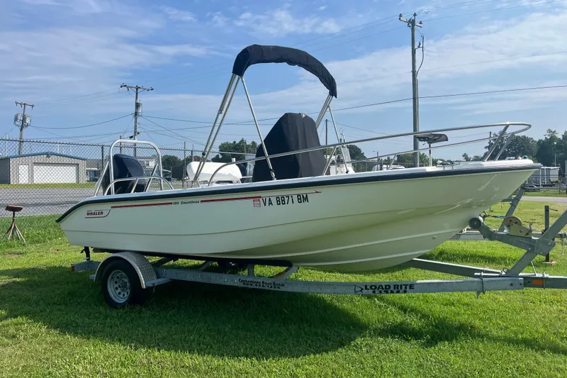 Slide: The Image of 2007 Boston Whaler 180 Dauntless boat on trailer, parked on grass. - 16