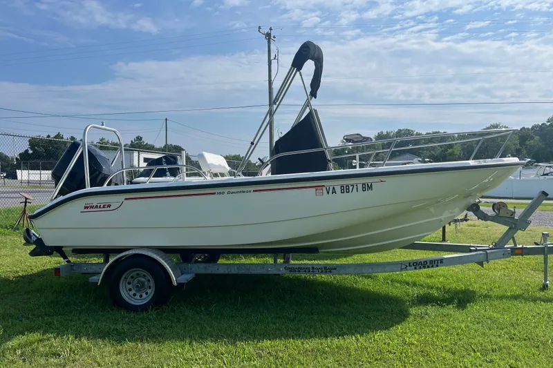 The Image of 2007 Boston Whaler 180 Dauntless boat on trailer, parked on grass under blue sky. - 0