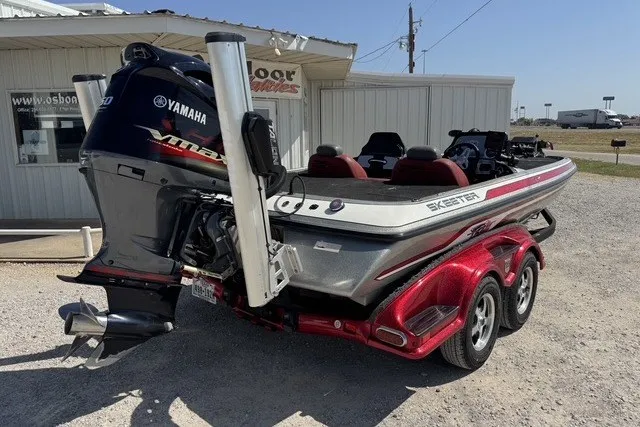 Slide: The Image of 2013 Skeeter FX21 bass boat with Yamaha engine, parked on a red trailer. - 2